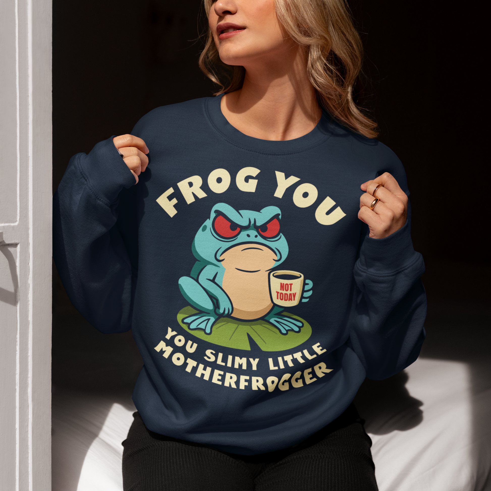 Frog You Motherfrogger Sweathirt - Angry Frog Shirt - Funny Animal Meme Top - Frog Lover Gift. Serve attitude with a side of caffeine in this bold and hilarious “Frog Off Motherfrogger” shirt. Featuring a grumpy frog perched on a lily pad, clutching a “Not Today” coffee mug, this design perfectly captures those moods when patience is low and sarcasm is high. With its cheeky wordplay and expressive character, it’s the ultimate statement piece for anyone who appreciates humor with a bite.