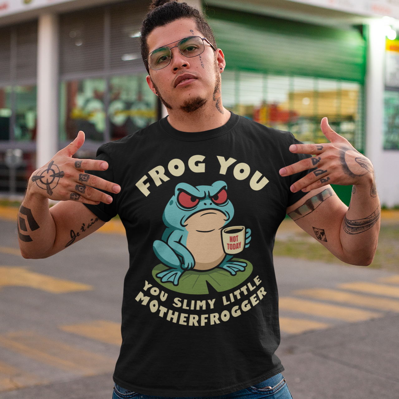 Frog You Motherfrogger T-Shirt - Angry Frog Shirt - Funny Animal Meme Tee - Frog Lover Gift. Serve attitude with a side of caffeine in this bold and hilarious “Frog Off Motherfrogger” shirt. Featuring a grumpy frog perched on a lily pad, clutching a “Not Today” coffee mug, this design perfectly captures those moods when patience is low and sarcasm is high. With its cheeky wordplay and expressive character, it’s the ultimate statement piece for anyone who appreciates humor with a bite.