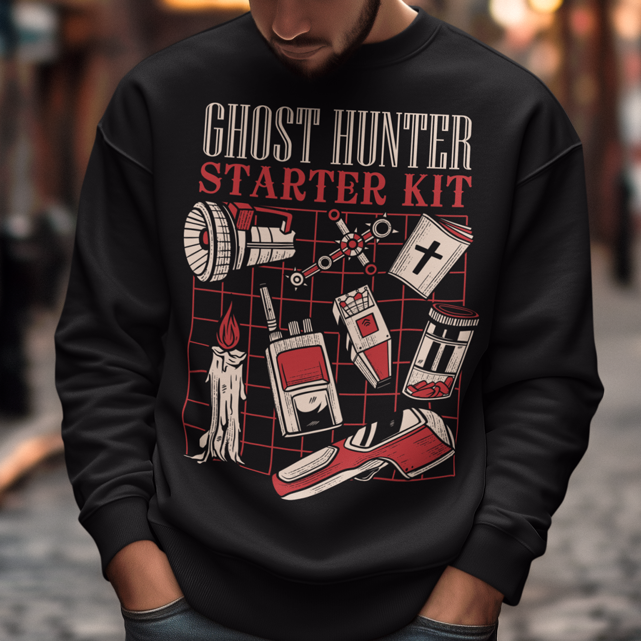 Step into the shadows with this Ghost Hunter Starter Kit sweatshirt, a perfect blend of spooky humor and paranormal adventure. Designed for fans of ghost hunting, horror culture, and all things supernatural, this bold graphic tee features a vintage-style layout packed with classic ghost hunting essentials like an EMF reader, flashlight, candle, spirit box, holy book, and more. The striking red and off-white artwork pops against the black fabric, giving it a retro paranormal investigator vibe.