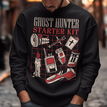Step into the shadows with this Ghost Hunter Starter Kit sweatshirt, a perfect blend of spooky humor and paranormal adventure. Designed for fans of ghost hunting, horror culture, and all things supernatural, this bold graphic tee features a vintage-style layout packed with classic ghost hunting essentials like an EMF reader, flashlight, candle, spirit box, holy book, and more. The striking red and off-white artwork pops against the black fabric, giving it a retro paranormal investigator vibe.