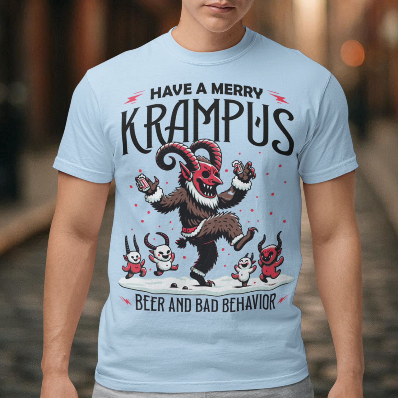 The T-shirt design features Krampus in a festive yet mischievous scene, decked out in holiday cheer. Krampus, the legendary Christmas creature, is depicted dancing with a mischievous grin, holding a beer and surrounded by a few playful imps. Above the scene, bold black lettering reads, "HAVE A MERRY KRAMPUS," with a mix of gothic and playful fonts, giving it a fun yet eerie holiday vibe.