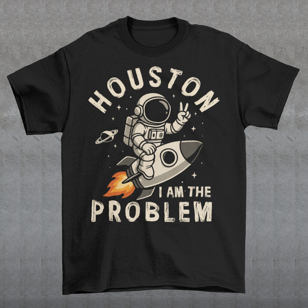 Make a statement that’s out of this world. This bold graphic tee features a fearless astronaut riding a rocket through space, throwing up a peace sign with cosmic confidence. Surrounding the design is the rebellious text: “HOUSTON I AM THE PROBLEM” — a playful twist on the classic space phrase. Perfect for space enthusiasts, rebels at heart, or anyone who loves a little cosmic humor.