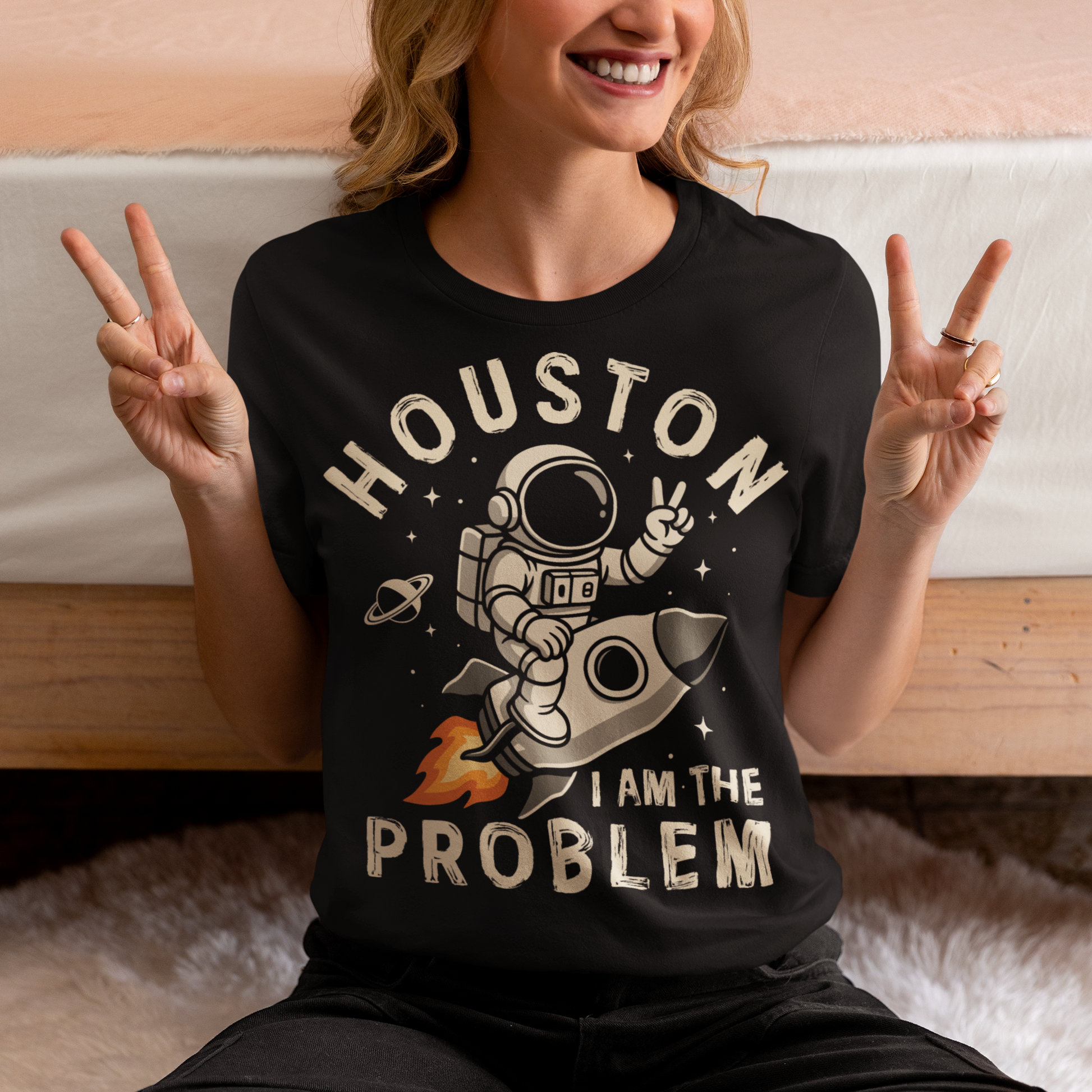 Make a statement that’s out of this world. This bold graphic tee features a fearless astronaut riding a rocket through space, throwing up a peace sign with cosmic confidence. Surrounding the design is the rebellious text: “HOUSTON I AM THE PROBLEM” — a playful twist on the classic space phrase. Perfect for space enthusiasts, rebels at heart, or anyone who loves a little cosmic humor.