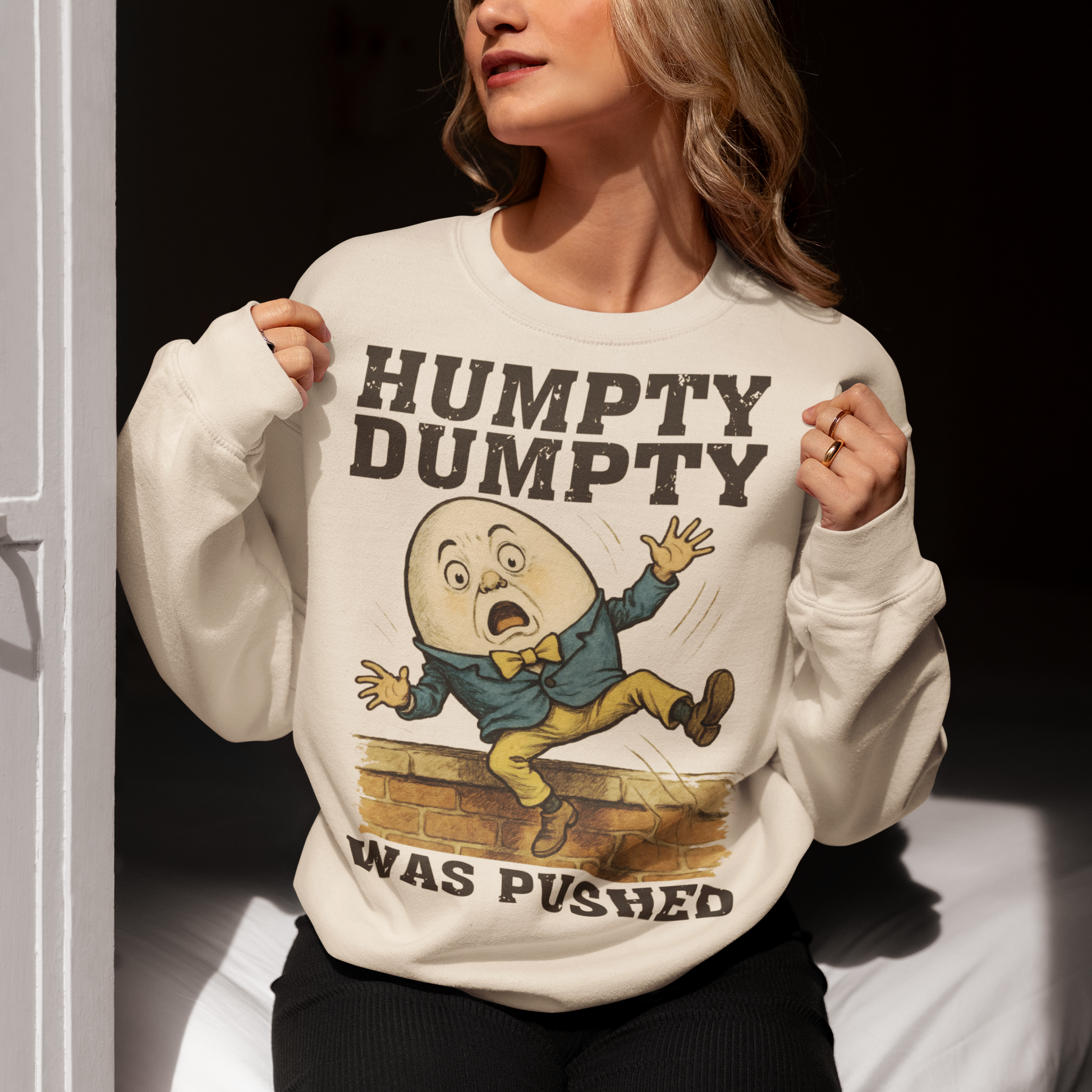 Make a bold statement with our "Humpty Dumpty Was Pushed" Sweatshirt — a clever twist on the classic nursery rhyme. Featuring a playful yet rebellious design of Humpty Dumpty mid-fall from his iconic wall, this shirt mixes dark humor with nostalgic charm. Perfect for anyone who loves witty graphics, conspiracy-style humor, or just wants to spark a few laughs and double-takes.