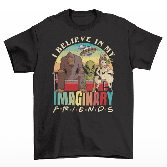 Black t-shirt of a Bigfoot, an alien and a unicorn sitting on a bench in front of a retro sun with text "I BELIEVE IN MY IMAGINARY FRIENDS".