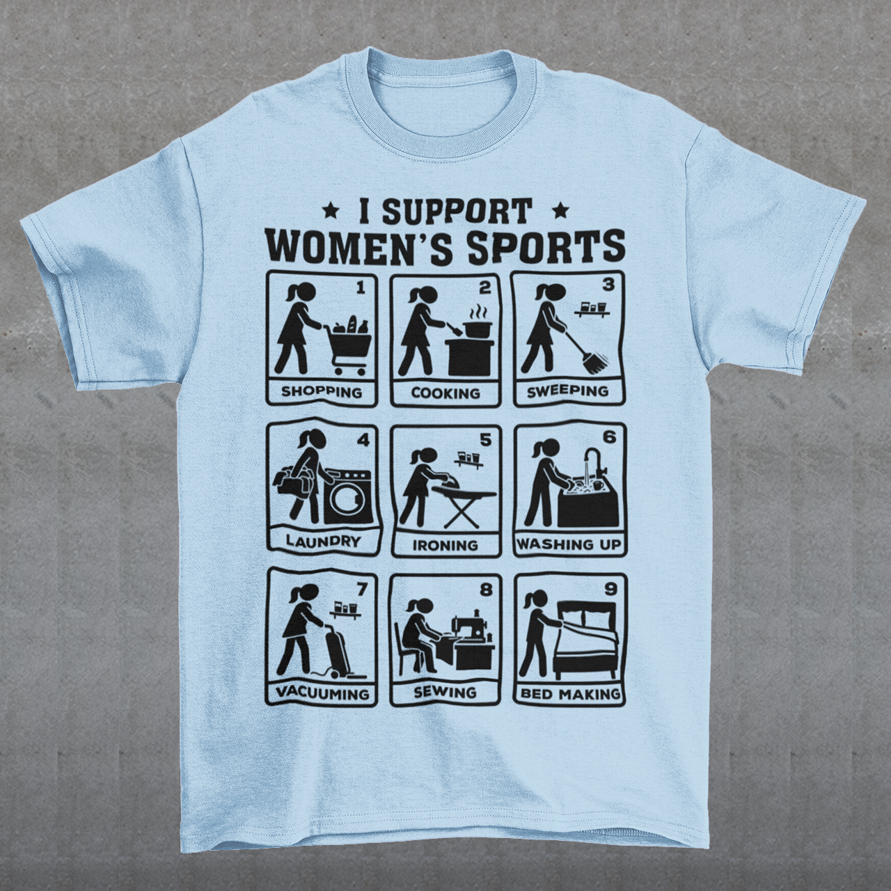 Light Blue t-shirt featuring the humorous phrase “I SUPPORT WOMEN’S SPORTS” with nine illustrated panels parodying different household activities: shopping, cooking, sweeping, laundry, ironing, washing up, vacuuming, sewing, and bed making. Black graphics create a retro sports-style design with a sarcastic, tongue-in-cheek theme.