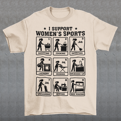 Beige t-shirt featuring the humorous phrase “I SUPPORT WOMEN’S SPORTS” with nine illustrated panels parodying different household activities: shopping, cooking, sweeping, laundry, ironing, washing up, vacuuming, sewing, and bed making. Black graphics create a retro sports-style design with a sarcastic, tongue-in-cheek theme.