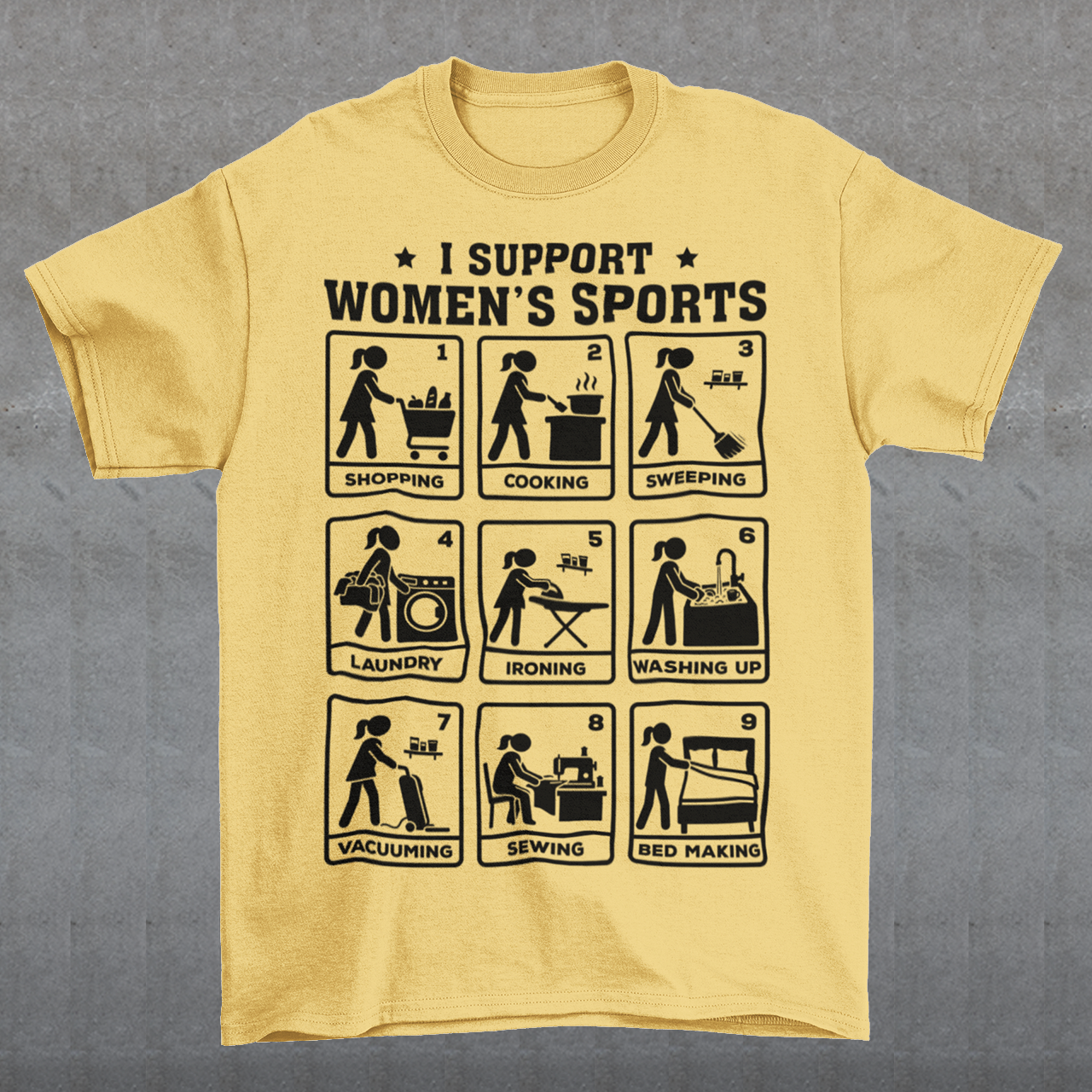Yellow t-shirt featuring the humorous phrase “I SUPPORT WOMEN’S SPORTS” with nine illustrated panels parodying different household activities: shopping, cooking, sweeping, laundry, ironing, washing up, vacuuming, sewing, and bed making. Black graphics create a retro sports-style design with a sarcastic, tongue-in-cheek theme.