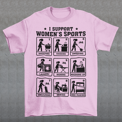 Pink t-shirt featuring the humorous phrase “I SUPPORT WOMEN’S SPORTS” with nine illustrated panels parodying different household activities: shopping, cooking, sweeping, laundry, ironing, washing up, vacuuming, sewing, and bed making. Black graphics create a retro sports-style design with a sarcastic, tongue-in-cheek theme.