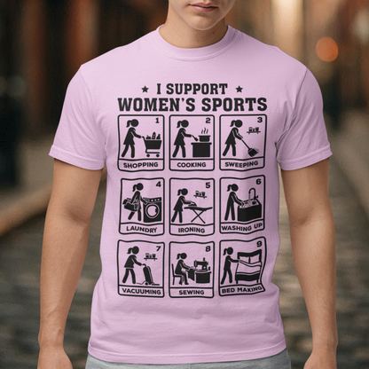 Pink t-shirt featuring the humorous phrase “I SUPPORT WOMEN’S SPORTS” with nine illustrated panels parodying different household activities: shopping, cooking, sweeping, laundry, ironing, washing up, vacuuming, sewing, and bed making. Black graphics create a retro sports-style design with a sarcastic, tongue-in-cheek theme.
