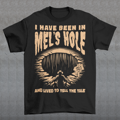 Step into the strange with this quirky and mysterious tee! Featuring a bold illustration of a curious man peering into a dark, bottomless abyss, this shirt pays homage to the legendary paranormal tale of Mel's Hole — a supposed infinite pit in the wilds of Washington State. The vintage-style artwork is topped with the eerie invitation: "VISIT MEL'S HOLE" in retro tourism font, blending humor, folklore, and a dash of the unexplained.