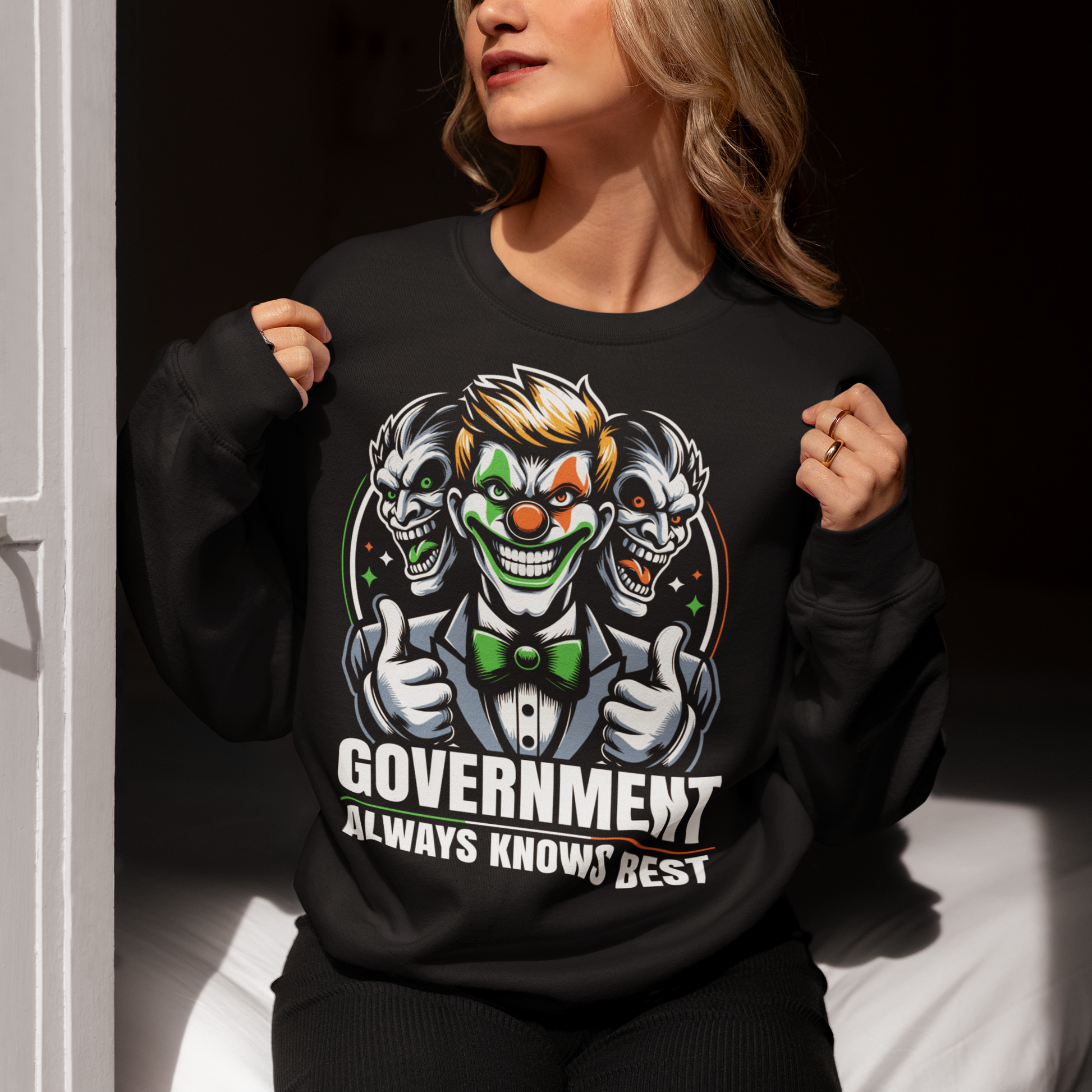 Black sweatshirt of a government clown with text GOVERNMENT ALWAYS KNOWS BEST.