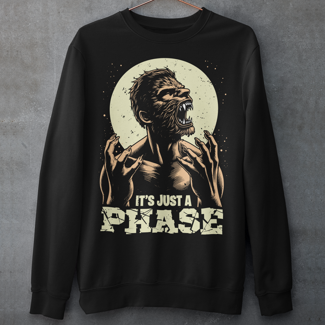 Black sweatshirt of a man transforming in to a werewolf with text underneath "IT'S JUST A PHASE."