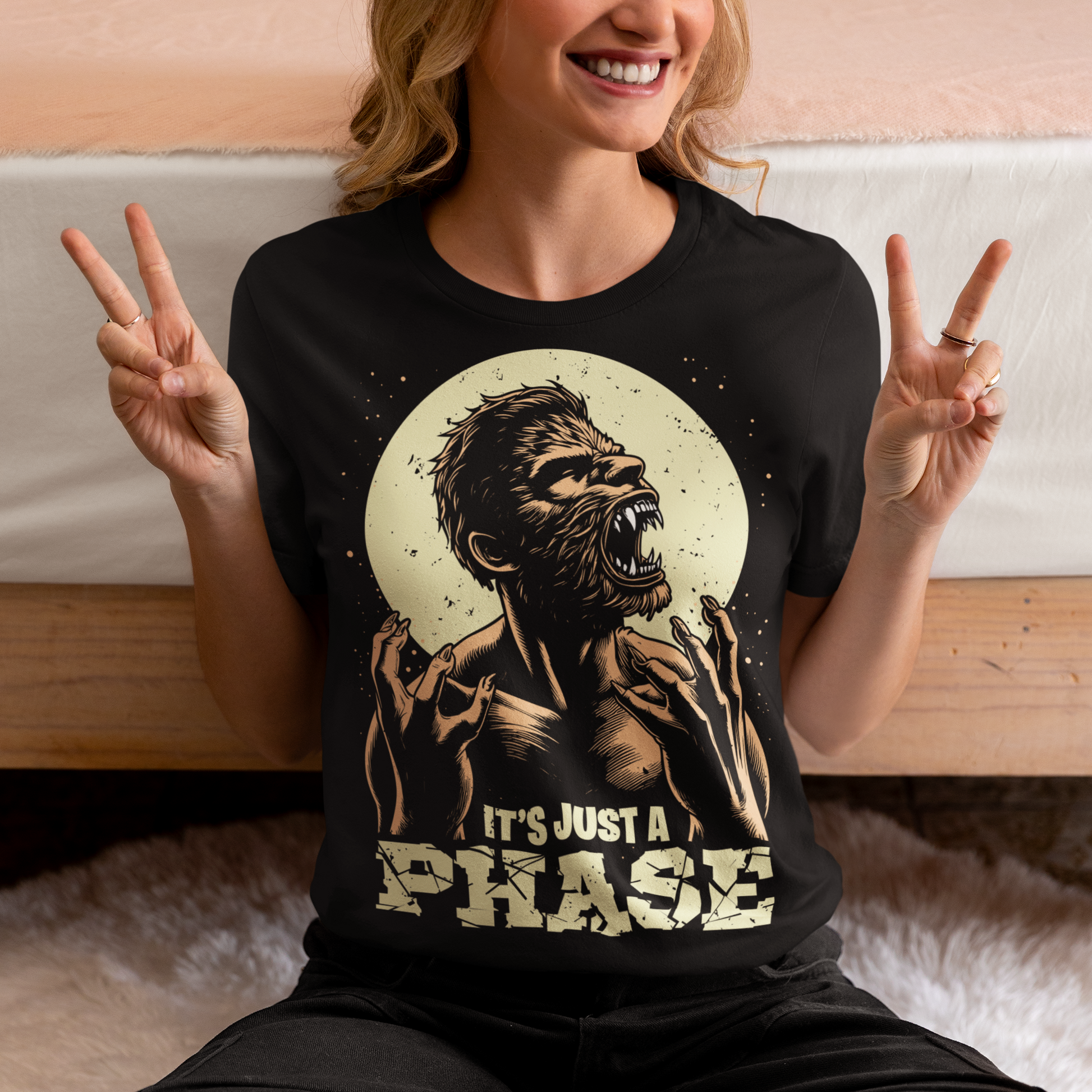 Black t-shirt of a man transforming in to a werewolf with text underneath "IT'S JUST A PHASE."