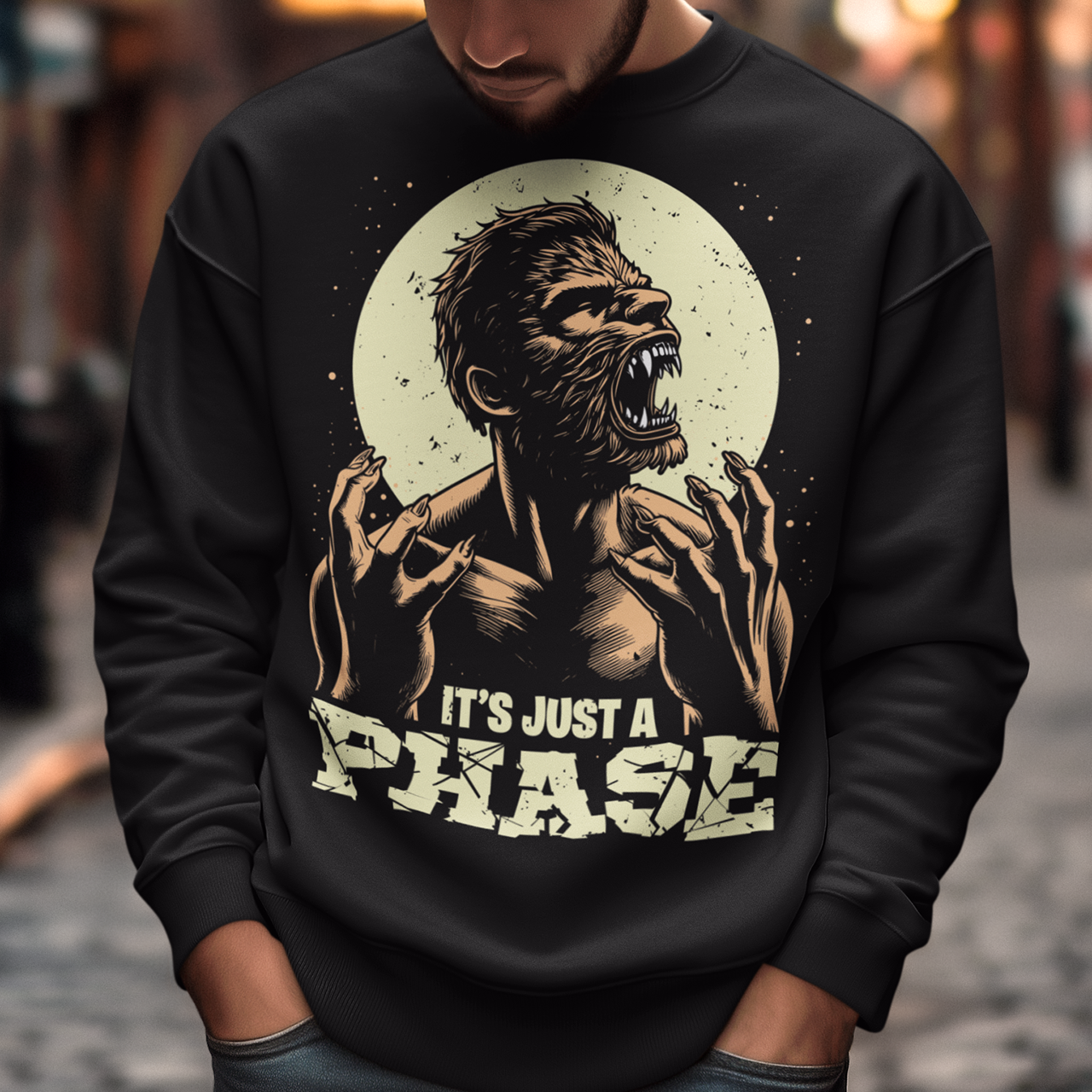 Black sweatshirt of a man transforming in to a werewolf with text underneath "IT'S JUST A PHASE."