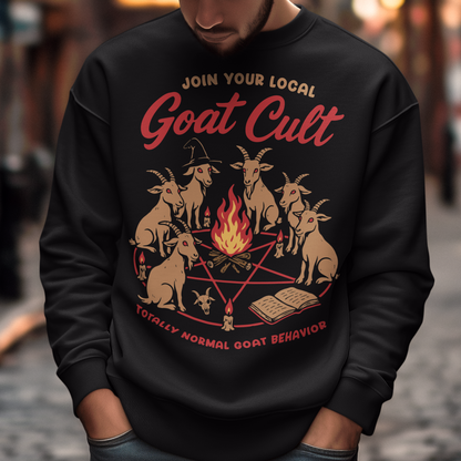 Black sweatshirt featuring a humorous occult-style graphic of goats gathered in a ritual circle around a fire with candles and symbols. Text reads “Join Your Local Goat Cult” with “Totally Normal Goat Behavior” underneath. The design has a playful spooky aesthetic with cartoon goats, making it a funny and quirky dark humor piece.
