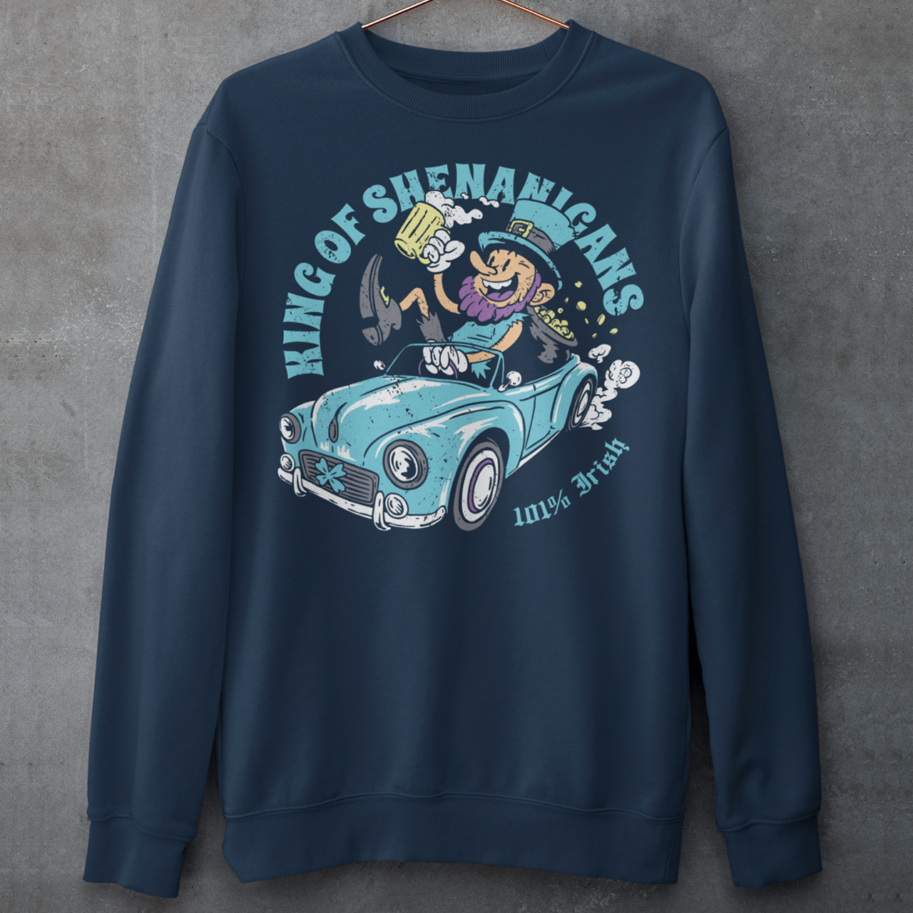 Navy sweatshirt with a leprechaun driving a car with text KING OF SHENANIGANS.