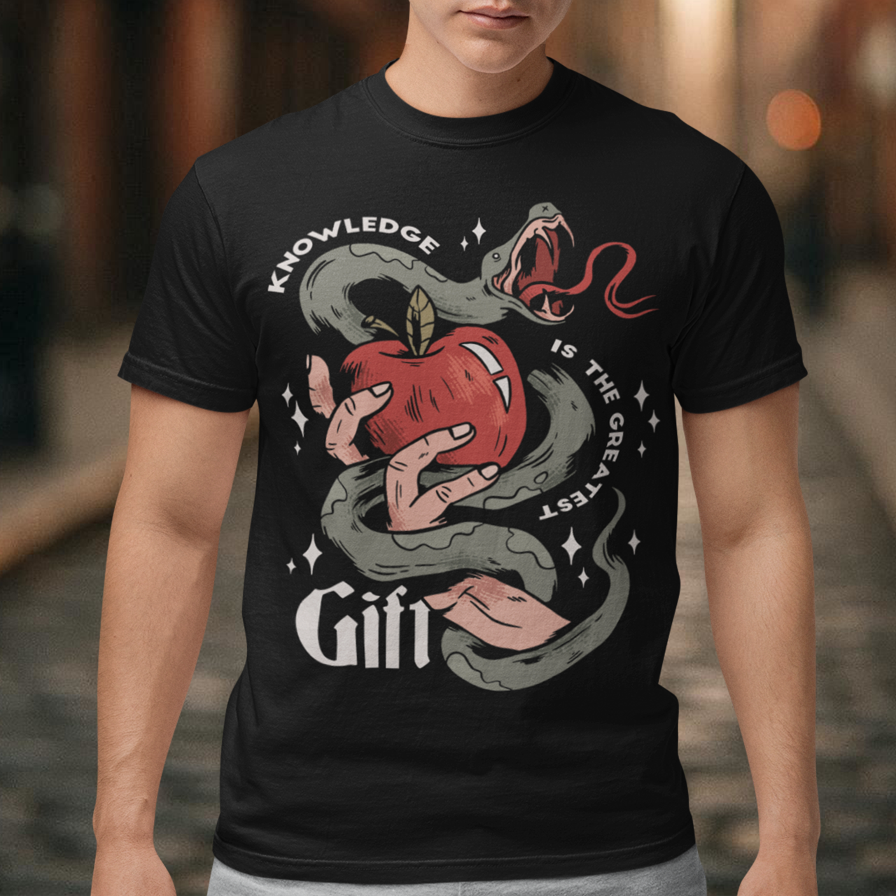 Introducing our captivating "Knowledge is the Greatest Gift" T-shirt – a design that seamlessly blends symbolism and style. Centered on the tee is a powerful image: a meticulously drawn hand cradling a luscious apple, artfully encased in the sinuous coils of a serpent. This iconic representation pays homage to the age-old biblical tale of Adam and Eve, where the apple, symbolizing knowledge, is intertwined with the cunning serpent.