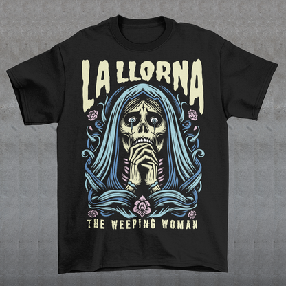 This striking La Llorona t-shirt features a haunting depiction of the legendary Weeping Woman, her ghostly figure shrouded in mist, with flowing hair and a sorrowful expression as she searches for her lost children. The design captures the eerie, chilling essence of the famous Latin American folktale, blending dark, gothic tones with an ethereal glow. Above the image, bold lettering reads "LA LLORONA", while below, the translation "THE WEEPING WOMAN" adds to the eerie mystique.