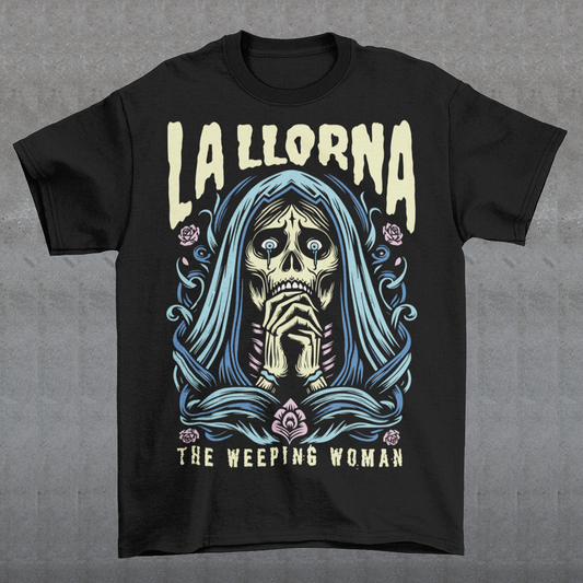 This striking La Llorona t-shirt features a haunting depiction of the legendary Weeping Woman, her ghostly figure shrouded in mist, with flowing hair and a sorrowful expression as she searches for her lost children. The design captures the eerie, chilling essence of the famous Latin American folktale, blending dark, gothic tones with an ethereal glow. Above the image, bold lettering reads "LA LLORONA", while below, the translation "THE WEEPING WOMAN" adds to the eerie mystique.