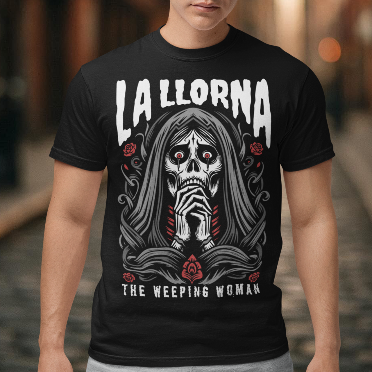 This striking La Llorona t-shirt features a haunting depiction of the legendary Weeping Woman, her ghostly figure shrouded in mist, with flowing hair and a sorrowful expression as she searches for her lost children. The design captures the eerie, chilling essence of the famous Latin American folktale, blending dark, gothic tones with an ethereal glow. Above the image, bold lettering reads "LA LLORONA", while below, the translation "THE WEEPING WOMAN" adds to the eerie mystique.