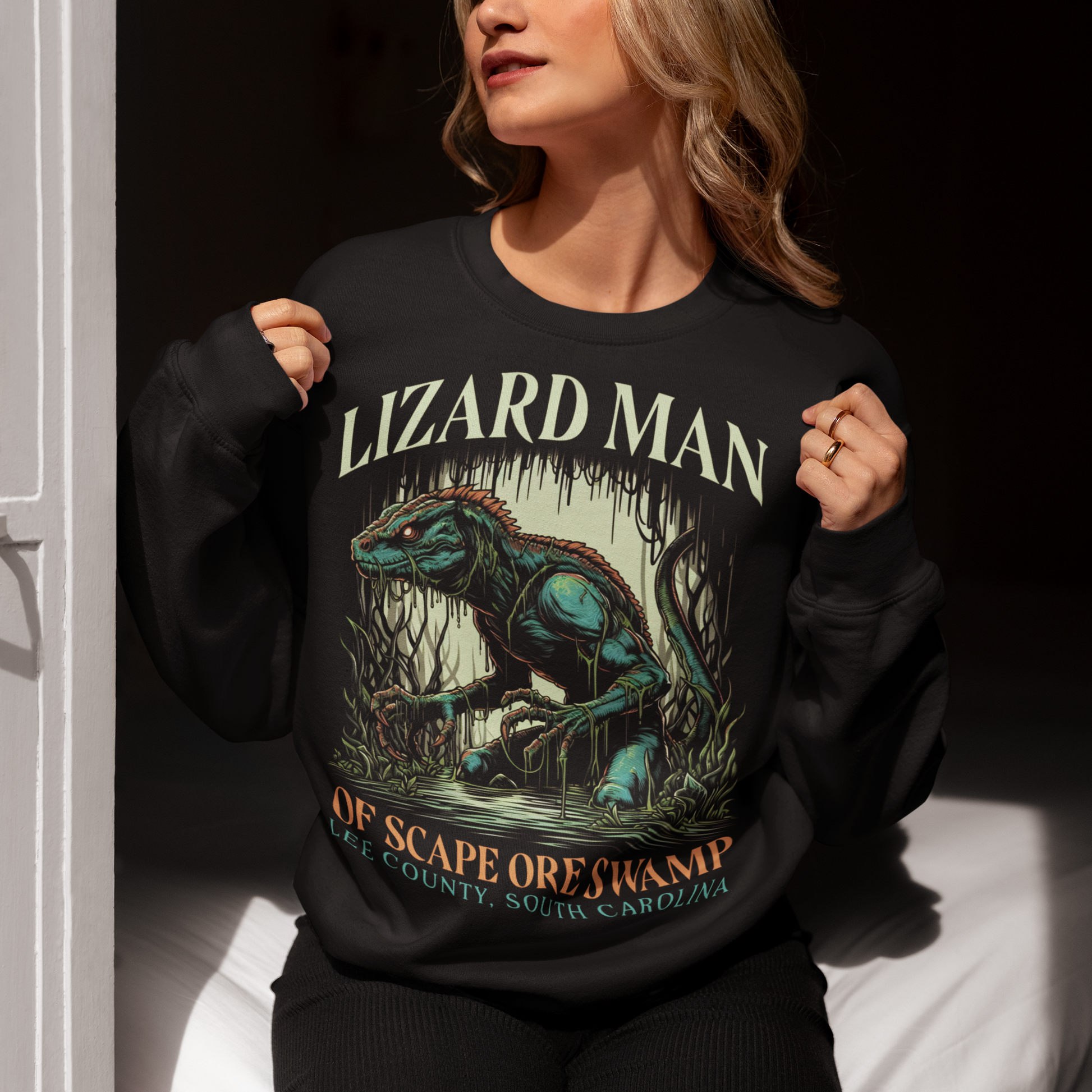 Black sweatshirt of a Lizard man in a swamp with text "LIZARD MAN OF SCAPE ORE SWAMP".