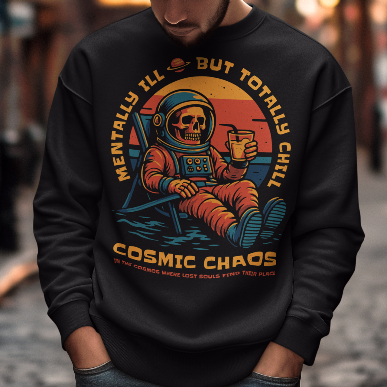 This black graphic sweatshirt features a laid-back skeleton astronaut floating in cosmic calm, drink in hand, as the universe quietly burns behind him. Bold retro colors and sunset tones frame the scene, while the phrase “Mentally Ill But Totally Chill” wraps the design with dark humor and self-aware wit. Anchored by the tagline Cosmic Chaos, it feels like a space-age postcard from the edge of existence.