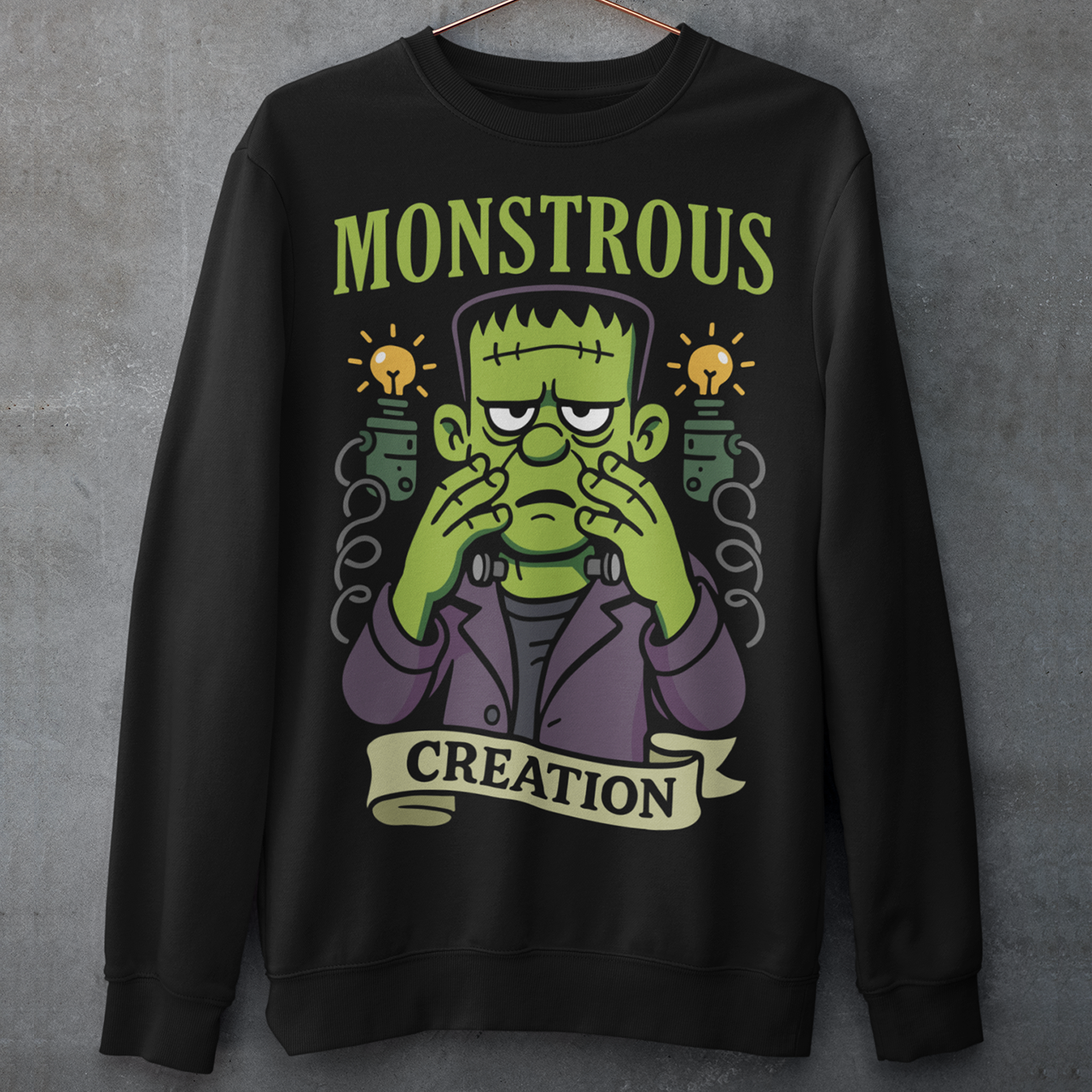 Monstrous creation sweatshirt - Frankenstein shirt. Bring a spark of classic horror to your wardrobe with this bold “Monstrous Creation” sweatshirt. Featuring a grumpy, stitched-up Frankenstein brought to life in a playful cartoon style, this design is a fun tribute to vintage horror with a modern, humorous twist. Surrounded by crackling energy and glowing lab elements, the character captures that iconic “it’s alive!” moment, but with a perfectly unimpressed expression that steals the show.