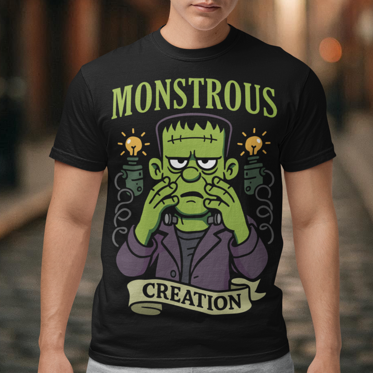 Monstrous creation t-shirt - Frankenstein shirt. Bring a spark of classic horror to your wardrobe with this bold “Monstrous Creation” t-shirt. Featuring a grumpy, stitched-up Frankenstein brought to life in a playful cartoon style, this design is a fun tribute to vintage horror with a modern, humorous twist. Surrounded by crackling energy and glowing lab elements, the character captures that iconic “it’s alive!” moment, but with a perfectly unimpressed expression that steals the show.