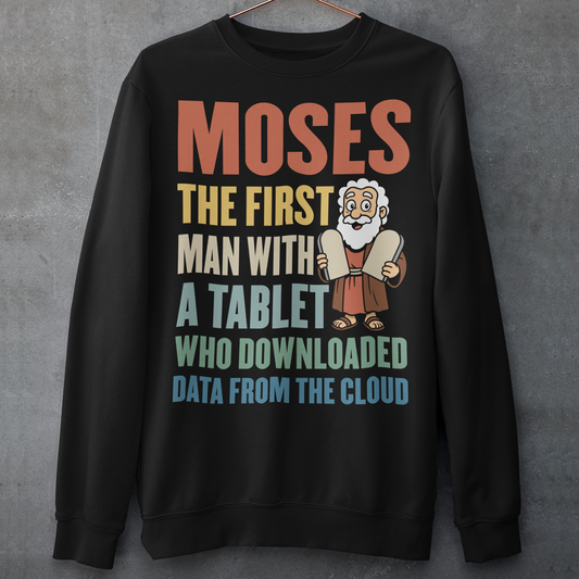 Black sweatshirt featuring a humorous graphic of Moses holding stone tablets with colorful text that reads “Moses the first man with a tablet who downloaded data from the cloud.” The design uses a playful, retro style with multicolored lettering and a cartoon illustration, combining biblical imagery with modern tech humor.
