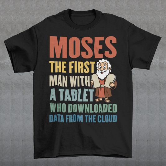 Black t-shirt featuring a humorous graphic of Moses holding stone tablets with colorful text that reads “Moses the first man with a tablet who downloaded data from the cloud.” The design uses a playful, retro style with multicolored lettering and a cartoon illustration, combining biblical imagery with modern tech humor.