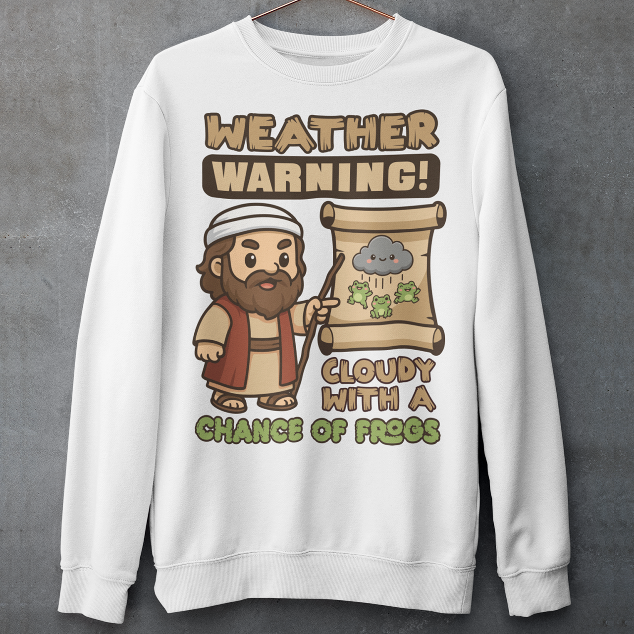 White sweatshirt featuring a cute cartoon Moses pointing at a weather scroll that shows a smiling rain cloud and falling frogs. The text reads “Weather Warning! Cloudy With a Chance of Frogs.” The design uses playful retro colors with funny biblical humor inspired by the plague of frogs story.