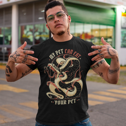 Introducing our edgy and eye-catching t-shirt, where the wild meets the witty: the "MY PET CAN EAT YOUR PET" design. This captivating piece effortlessly combines a striking image of a sinuous and intricately detailed snake with a bold proclamation that's sure to turn heads. At the heart of the design is an incredibly lifelike depiction of a snake, coiled and ready to strike. The artistry and attention to detail showcase every scale, curve, and menacing gaze of this magnificent creature.