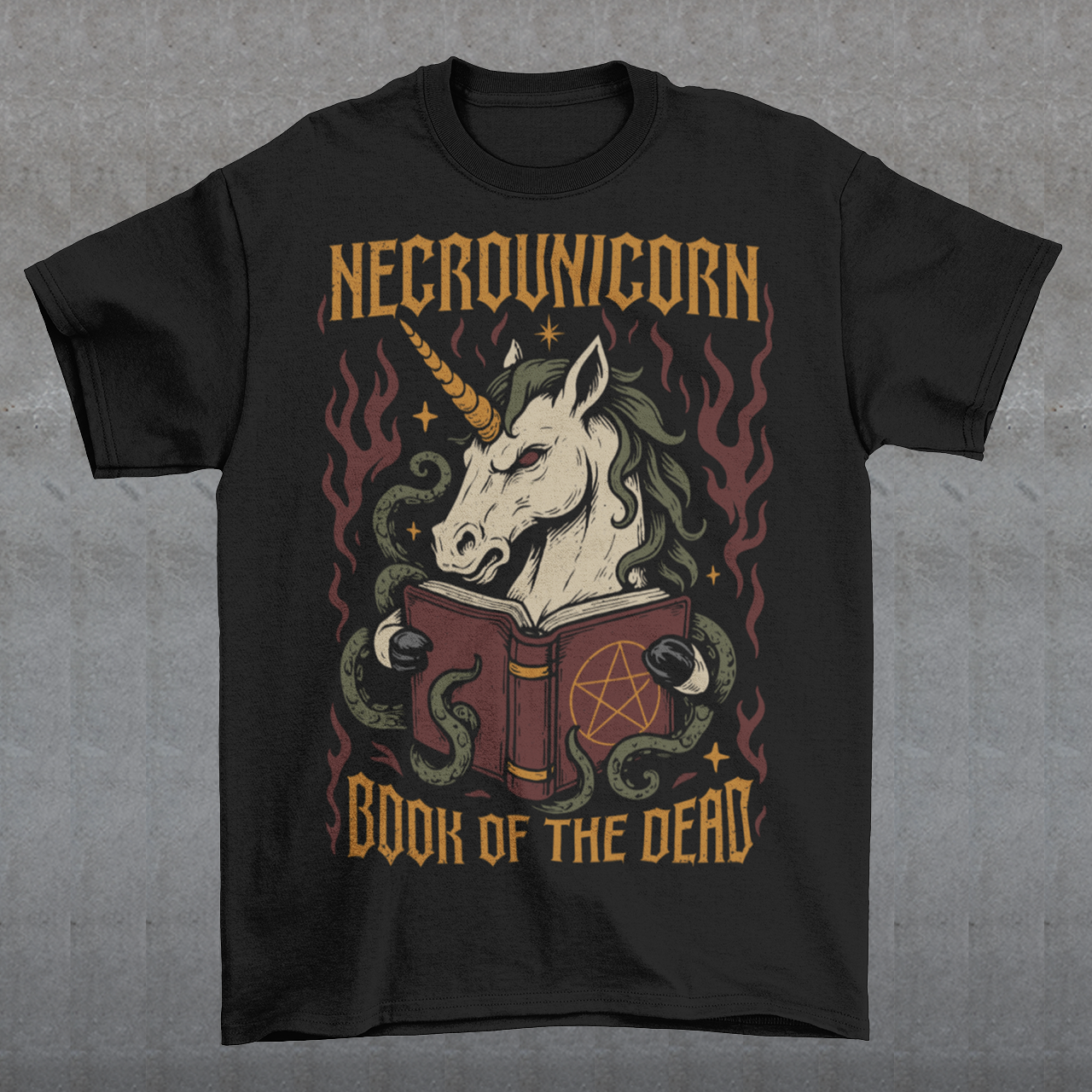 Black t-shirt featuring a dark fantasy graphic of an evil unicorn reading a spellbook with a pentagram symbol. The design includes flames, tentacles, stars, and gothic lettering reading “Necrounicorn” and “Book of the Dead.” Spooky occult-inspired artwork with horror, witchcore, and fantasy aesthetics.