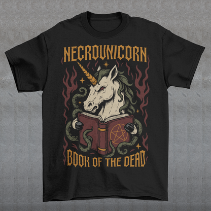 Black t-shirt featuring a dark fantasy graphic of an evil unicorn reading a spellbook with a pentagram symbol. The design includes flames, tentacles, stars, and gothic lettering reading “Necrounicorn” and “Book of the Dead.” Spooky occult-inspired artwork with horror, witchcore, and fantasy aesthetics.