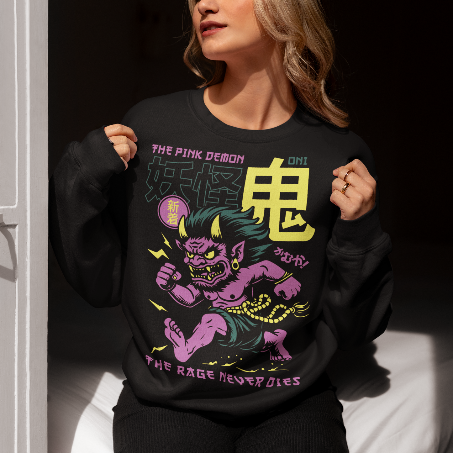Bold, fierce, and unstoppable — this dynamic sweatshirt features a powerful Japanese Oni mid-sprint, eyes blazing and muscles tense with fury. Above the image, bold text declares "THE PINK DEMON", while below, a chilling reminder reads: "THE RAGE NEVER DIES". This shirt captures the raw energy and mythic wrath of the Oni spirit — perfect for those who embrace intensity and never back down.