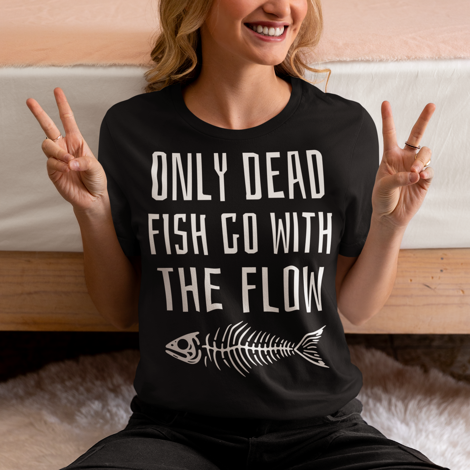 Introducing our bold and thought-provoking t-shirt that features a striking design: a fish skeleton, paired with the empowering message "ONLY DEAD FISH GO WITH THE FLOW." This tee is perfect for those who pride themselves on swimming against the tide and embracing their individuality. The fish skeleton, rendered in a minimalist yet impactful style, symbolizes the importance of standing out and making your own path.