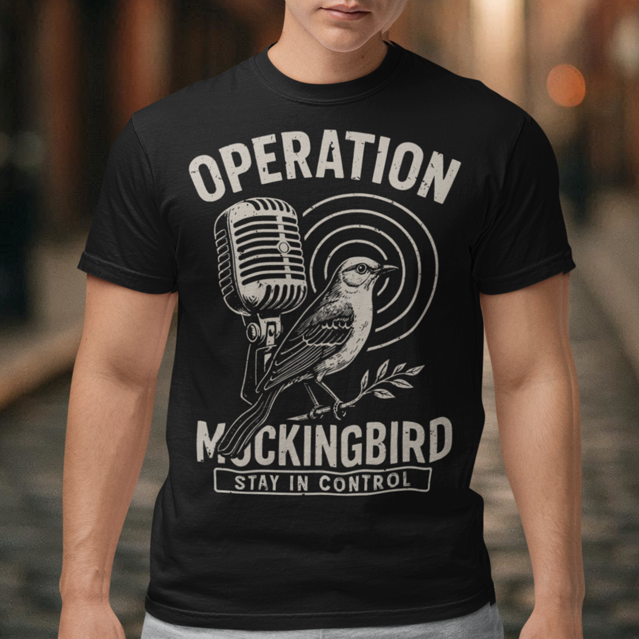 Celebrate a fascinating piece of Cold War history with this Operation Mockingbird tee. Featuring a sleek graphic of a mockingbird perched on a microphone, the design nods to the program that sought to influence news media during the mid-20th century. Perfect for history enthusiasts, political science buffs, and anyone who loves thought-provoking apparel.