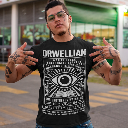 This black shirt channels the unsettling spirit of George Orwell’s 1984 with bold, high-contrast artwork and iconic slogans that refuse to whisper. The all-seeing eye dominates the design, flanked by surveillance cameras, burning torches, and an open book, a visual chorus of control, truth, and resistance. Phrases like “War Is Peace,” “Freedom Is Slavery,” and “Ignorance Is Strength” sit beneath the unmistakable warning: Big Brother Is Watching.