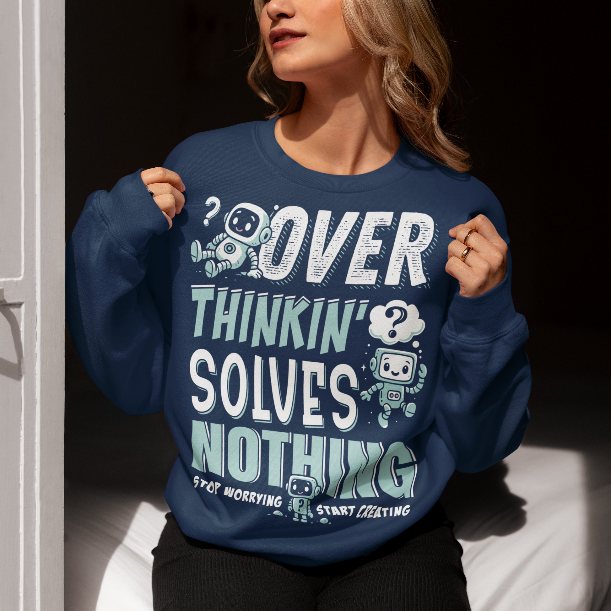 Break the cycle of overthinking in style with this uplifting graphic sweatshirt featuring adorable retro robots and the bold message: “Over Thinkin’ Solves Nothing — Stop Worrying, Start Creating.” This design blends playful charm with a motivating reminder to take action instead of stressing. Perfect for artists, students, creators, or anyone who needs a boost of encouragement, this shirt makes a thoughtful gift and a daily wearable mantra.