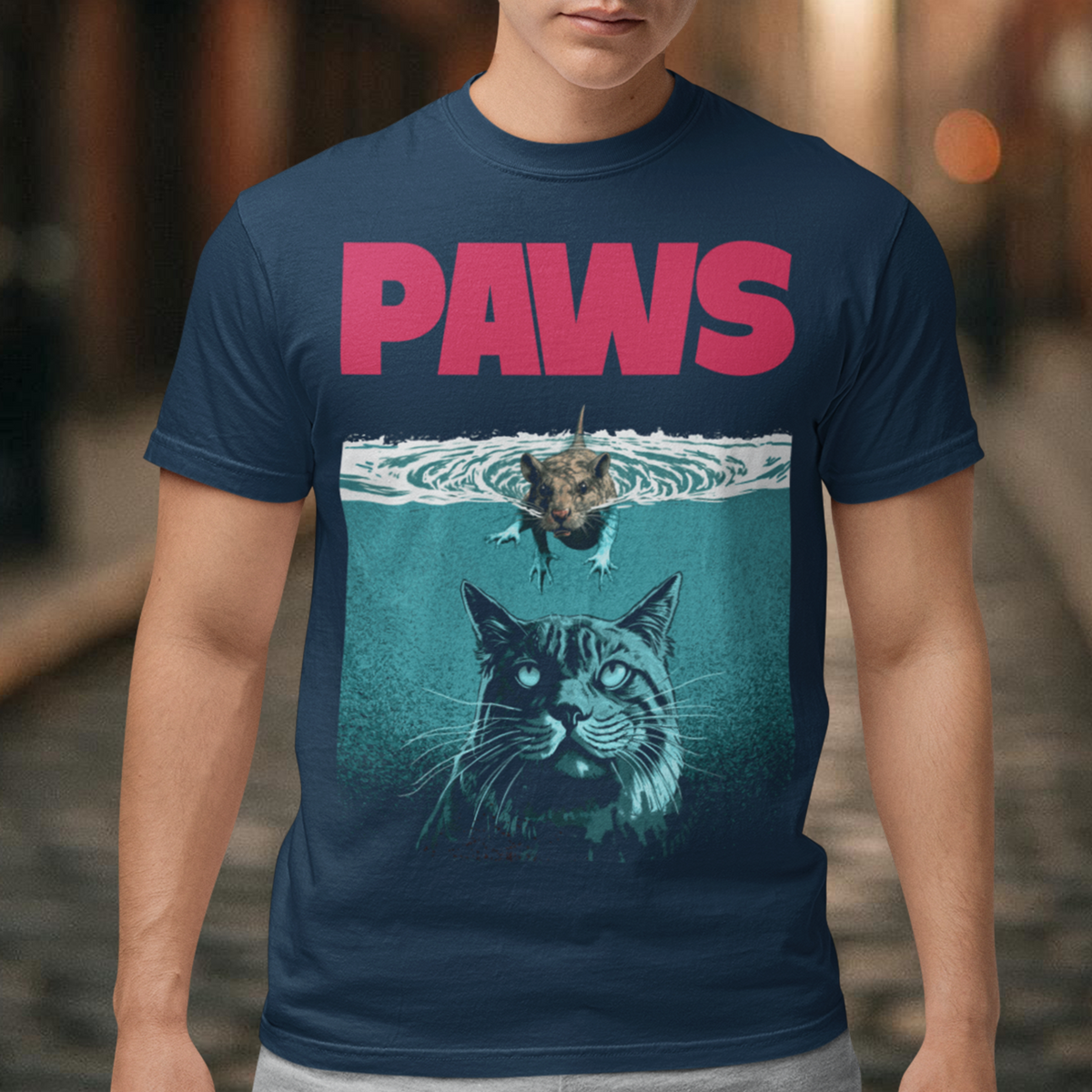 Introducing our "PAWS" T-shirt, a captivating and whimsical design that captures the perfect balance between playful and daring. This delightful shirt features an adorable little mouse fearlessly swimming on the water's surface, exuding confidence as it glides through the gentle ripples. The mouse appears relaxed and cheerful, as if it has found its true element in the aquatic world. Beneath the water, lurking stealthily, is the unmistakable silhouette of a cat.