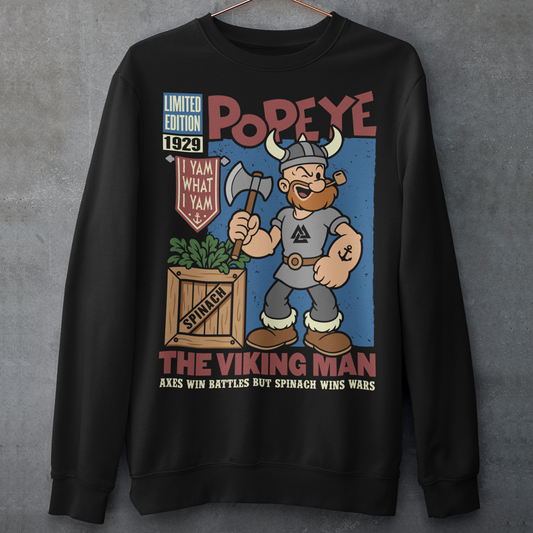 Channel old-school cartoon strength with this bold Popeye Viking graphic sweatshirt, where classic sailor swagger sails north into Viking territory. This playful design features a bearded Viking version of the legendary spinach-powered sailor, proudly gripping an axe beside a crate of spinach. With retro comic styling, vintage textures, and the iconic phrase “I Yam What I Yam,” the artwork celebrates the timeless humor and toughness that made the character famous.