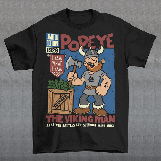 Channel old-school cartoon strength with this bold Popeye Viking graphic t-shirt, where classic sailor swagger sails north into Viking territory. This playful design features a bearded Viking version of the legendary spinach-powered sailor, proudly gripping an axe beside a crate of spinach. With retro comic styling, vintage textures, and the iconic phrase “I Yam What I Yam,” the artwork celebrates the timeless humor and toughness that made the character famous.