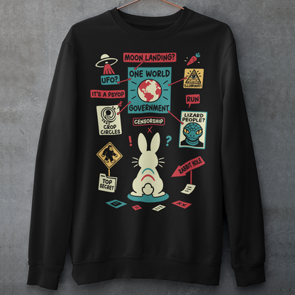 Black sweatshirt featuring a humorous conspiracy theory design with a confused rabbit standing before a bulletin board connected by red strings. The artwork includes UFOs, moon landing, lizard people, crop circles, Bigfoot, Illuminati, censorship, psyops, and rabbit hole references in a colorful retro style. A funny graphic tee for fans of conspiracies, cryptids, aliens, internet memes, and mystery-themed humor.