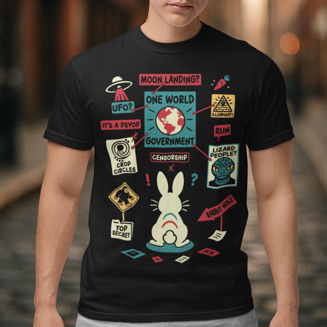 Black t-shirt featuring a humorous conspiracy theory design with a confused rabbit standing before a bulletin board connected by red strings. The artwork includes UFOs, moon landing, lizard people, crop circles, Bigfoot, Illuminati, censorship, psyops, and rabbit hole references in a colorful retro style. A funny graphic tee for fans of conspiracies, cryptids, aliens, internet memes, and mystery-themed humor.