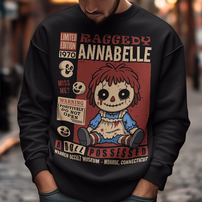 Stay cozy with a creepy-cute twist in this horror-themed sweatshirt featuring a distressed vintage doll design inspired by classic haunted-toy aesthetics. The graphic showcases a stitched, wide-eyed rag-style doll surrounded by spooky warning labels and retro horror elements, giving it the look of an old collectible poster. This shirt is ideal for horror fans, lovers of eerie artwork, and anyone who enjoys adding a little dark charm to their wardrobe.
