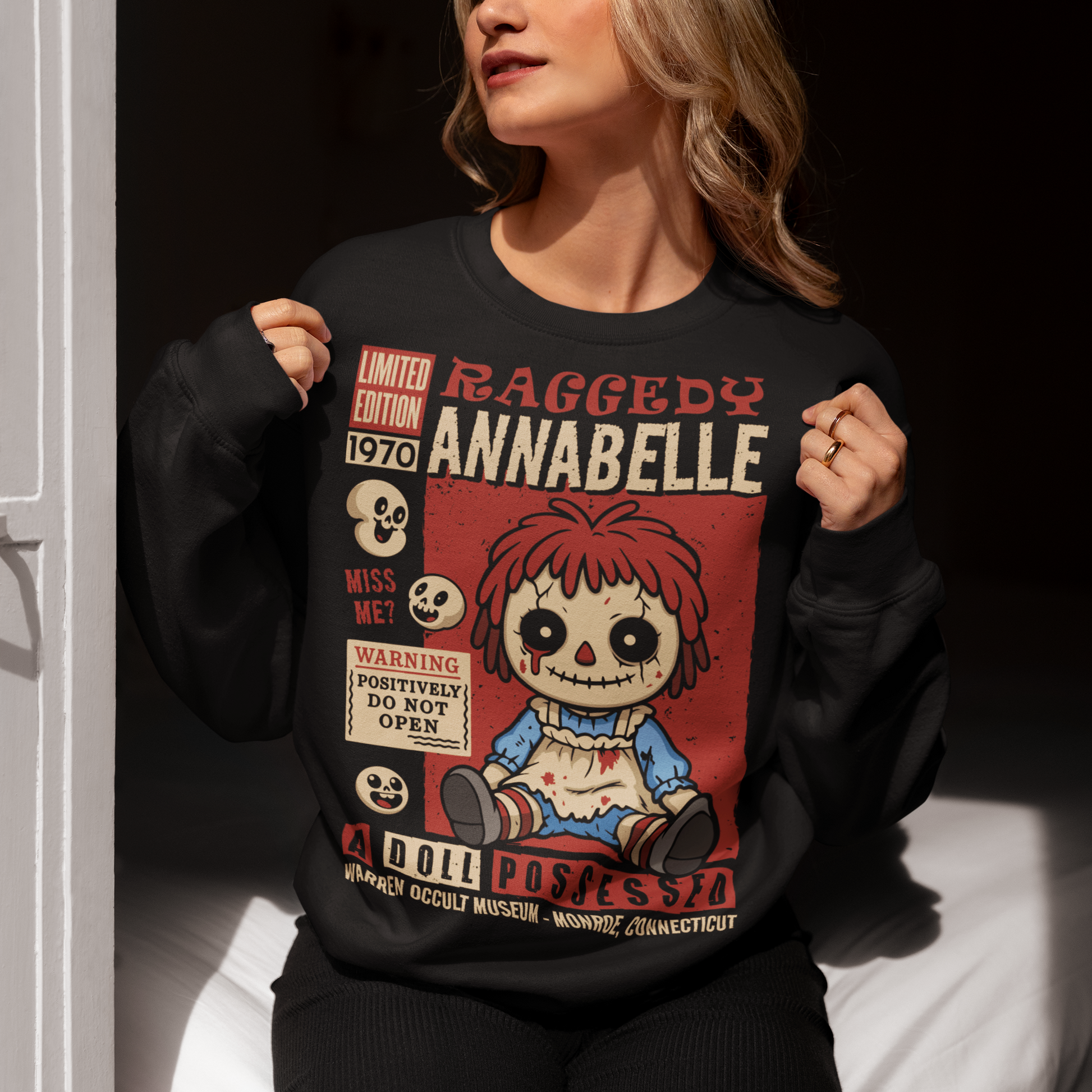 Stay cozy with a creepy-cute twist in this horror-themed sweatshirt featuring a distressed vintage doll design inspired by classic haunted-toy aesthetics. The graphic showcases a stitched, wide-eyed rag-style doll surrounded by spooky warning labels and retro horror elements, giving it the look of an old collectible poster. This shirt is ideal for horror fans, lovers of eerie artwork, and anyone who enjoys adding a little dark charm to their wardrobe.