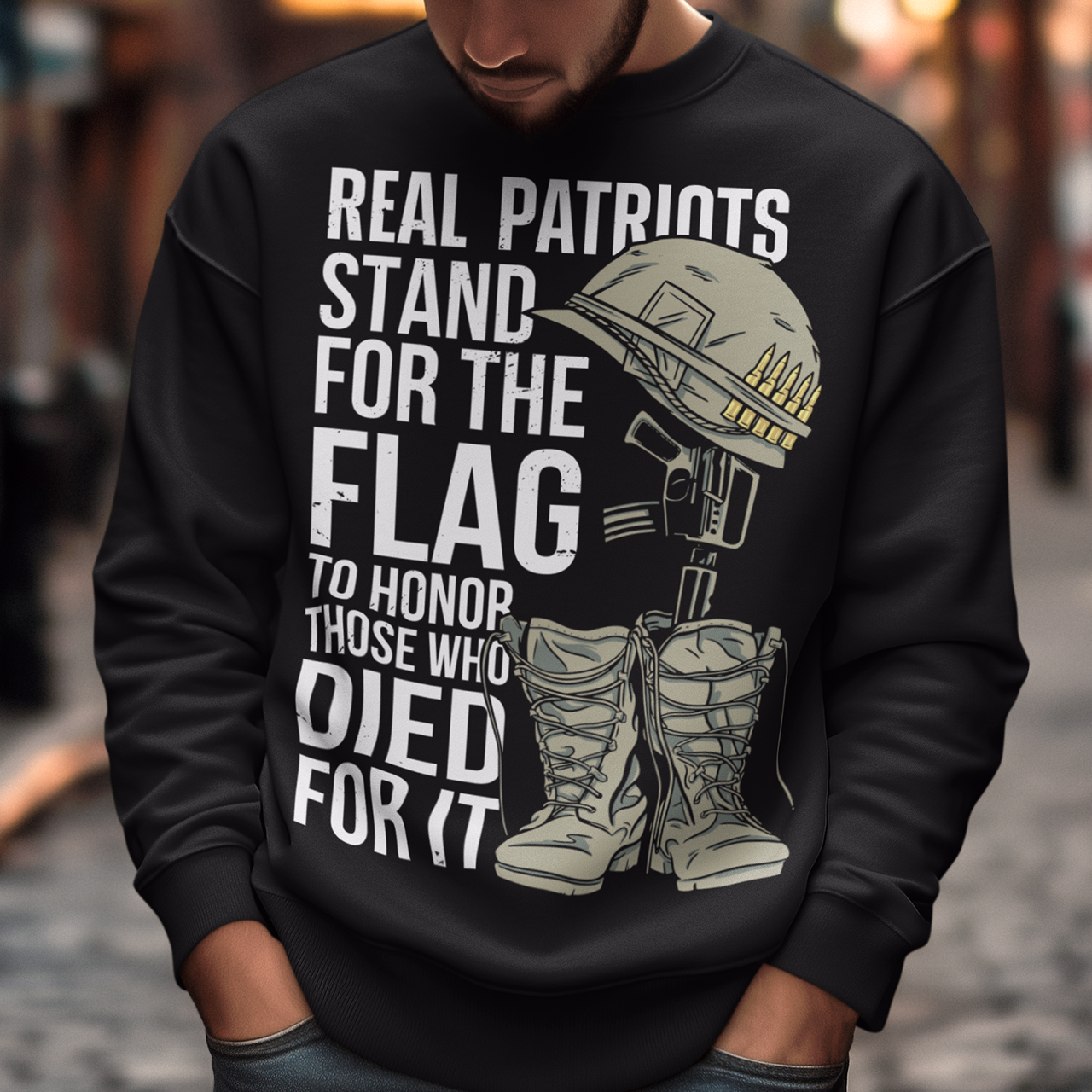 Sweatshirt design featuring a graphic of a military helmet resting on a rifle, which is standing upright in a pair of combat boots—a battlefield cross symbolizing fallen soldiers. Above and below the image is bold text that reads: "REAL PATRIOTS STAND FOR THE FLAG TO HONOR THOSE WHO DIED FOR IT." The design uses patriotic imagery to emphasize respect and remembrance for military service members who have sacrificed their lives.