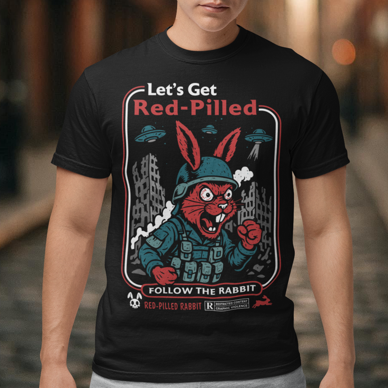 This black graphic tee dives headfirst down the rabbit hole. Featuring a fierce, red-eyed rabbit geared up like a rebel soldier, the design blends sci-fi paranoia, retro poster aesthetics, and counterculture attitude. Bold lettering reads “Let’s Get Red-Pilled” with “Follow the Rabbit” anchoring the scene, while crumbling cityscapes and hovering UFOs set a dystopian, mind-bending mood. This shirt feels like a lost propaganda poster from an alternate reality.