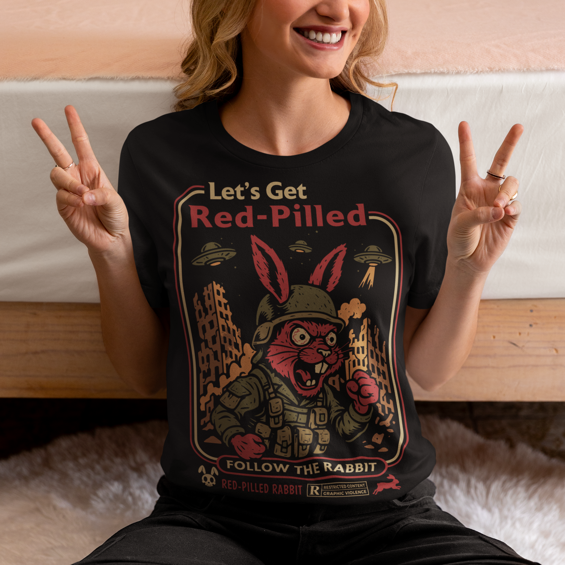 This black graphic tee dives headfirst down the rabbit hole. Featuring a fierce, red-eyed rabbit geared up like a rebel soldier, the design blends sci-fi paranoia, retro poster aesthetics, and counterculture attitude. Bold lettering reads “Let’s Get Red-Pilled” with “Follow the Rabbit” anchoring the scene, while crumbling cityscapes and hovering UFOs set a dystopian, mind-bending mood. This shirt feels like a lost propaganda poster from an alternate reality.